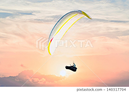 Paragliding, an adventure sport, free flight in nature under an orange sky at sunset. Sant Llorenc de Montgai, Noguera region, Lleida, Catalonia. 140317704