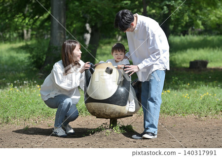 一家人在公園玩春季遊樂設施。 一家人在公園玩春季遊樂設施。 140317991