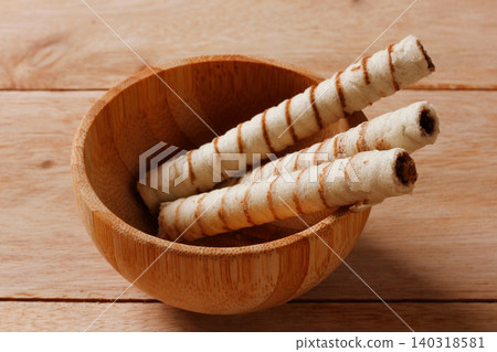 Three crispy wafer sticks filled with chocolate cream inside a handcrafted bamboo jar Three crispy wafer sticks filled with chocolate cream inside a handcrafted bamboo jar 140318581