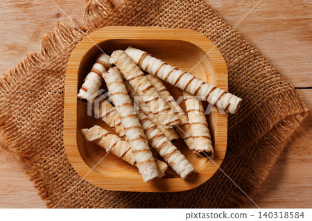Crispy wafer sticks filled with chocolate cream served in a small rustic bamboo bowl Crispy wafer sticks filled with chocolate cream served in a small rustic bamboo bowl 140318584