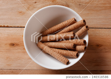 Crispy wafer sticks filled with chocolate cream served in a round white ceramic bowl. space for a copy. Crispy wafer sticks filled with chocolate cream served in a round white ceramic bowl. space for a copy. 140318586