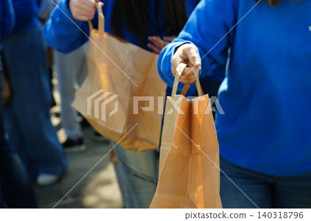 Volunteers Distributing Paper Bags at Community Event Volunteers Distributing Paper Bags at Community Event 140318796