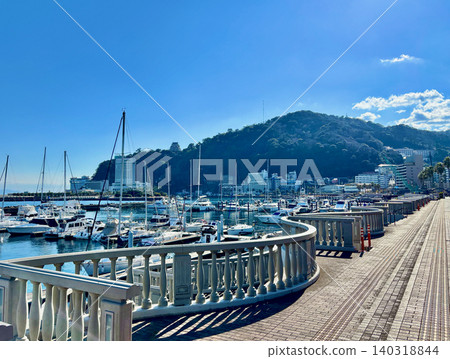 湛藍的天空、熱海港的遊艇碼頭以及從海濱公園看到的度假勝地景色。 湛藍的天空、熱海港的遊艇碼頭以及從海濱公園看到的度假勝地景色。 140318844