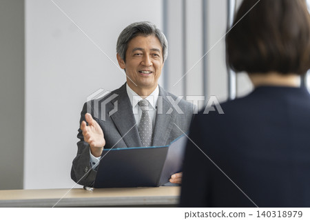 A smiling senior businessman speaking during an interview/meeting (image) A smiling senior businessman speaking during an interview/meeting (image) 140318979