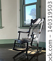 A classic wooden chair in a retro-style interior with white walls. 140319503