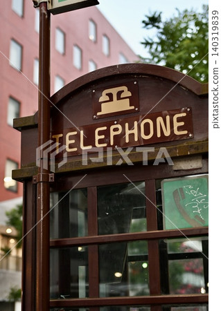 A classic wooden telephone booth standing on a street corner. A classic wooden telephone booth standing on a street corner. 140319839