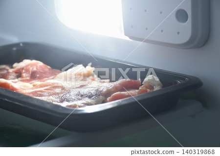 raw frozen beef meat slice roll ingredient food on black plastic tray in refrigerator raw frozen beef meat slice roll ingredient food on black plastic tray in refrigerator 140319868