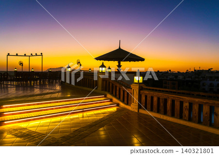 A magical sunrise over the sea with Egyptian resort hotels lining the coast. A vibrant, romantic resort landscape 140321801
