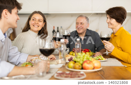 Girl enjoying family dinner with husband and parents-in-law 140321808