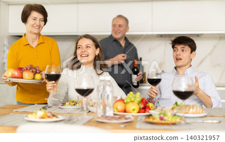 Father and mother together with adult children talking at dinner table at home Father and mother together with adult children talking at dinner table at home 140321957
