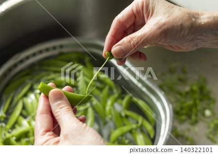 特寫鏡頭捕捉到豌豆莢上的繩子被拔掉的瞬間。 特寫鏡頭捕捉到豌豆莢上的繩子被拔掉的瞬間。 140322101