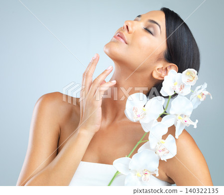 Flowers, skincare and woman with beauty, dermatology and person on a grey studio background. Model, luxury or girl with aesthetic or natural with facial or shine with glow and cosmetics with wellness Flowers, skincare and woman with beauty, dermatology and person on a grey studio background. Model, luxury or girl with aesthetic or natural with facial or shine with glow and cosmetics with wellness 140322135