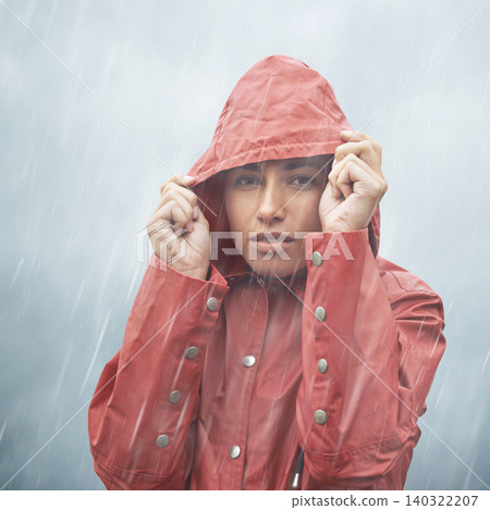Woman, protection and portrait with rain, coat and clouds with safety in nature. Girll, face and storm with cloudy, winter and waterproof hat for confidence and weather with adventure or vacation 140322207