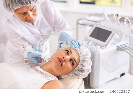 Young woman undergoing radiofrequency skin tightening procedure in cosmetic clinic Young woman undergoing radiofrequency skin tightening procedure in cosmetic clinic 140322337
