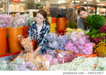 Female customer chooses a bouquet of Gypsophila in flower shop 140322457