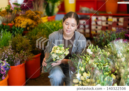 Girl salesman takes out bunch of eustoma from showcase, creates bouquets Girl salesman takes out bunch of eustoma from showcase, creates bouquets 140322506