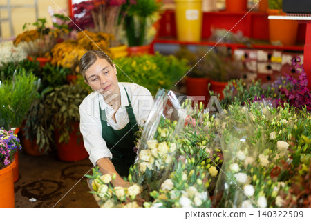Florist creates bouquet of roses in flower shop Florist creates bouquet of roses in flower shop 140322509