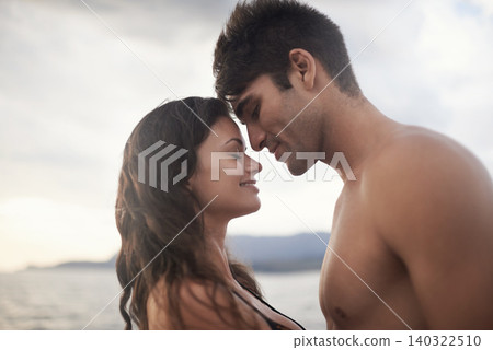 Love, happy couple and touch face at ocean for vacation, holiday or travel together in summer. Man, woman and intimate at sea for connection, care or bonding on adventure by water outdoor in nature 140322510