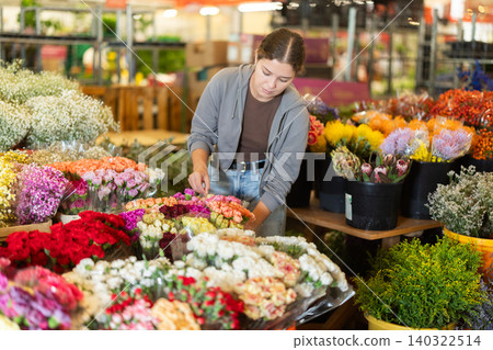 Female customer chooses a bouquet of carnations in flower shop Female customer chooses a bouquet of carnations in flower shop 140322514