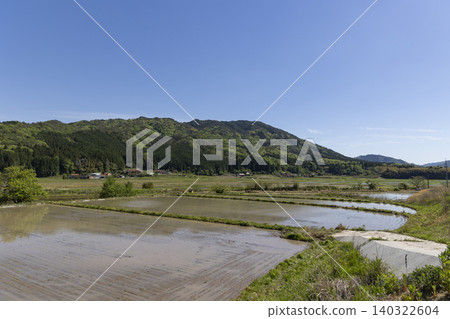 A panoramic view of rice paddies in spring, with mountains and a village in the background. A panoramic view of rice paddies in spring, with mountains and a village in the background. 140322604