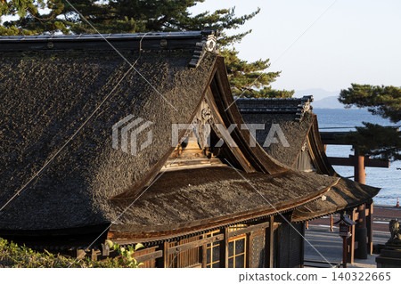 A thatched-roof shrine building and a lake landscape A thatched-roof shrine building and a lake landscape 140322665