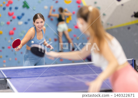Young girl and her companion are playing table tennis ping pong. Young girl and her companion are playing table tennis ping pong. 140322671