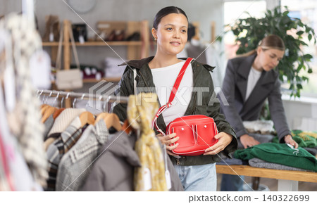 Adult woman choosing handbag in clothing store Adult woman choosing handbag in clothing store 140322699