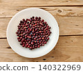 Fresh phalsa berries on white plate over rustic wooden table 140322969
