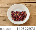 Phalsa fruit arranged by ripeness level on plate with wooden table background 140322978