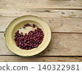 Spoiled phalsa berries and stems on old yellow plate with copy space 140322981