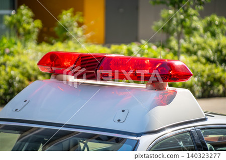 The red flashing lights of a police car shining in the backlight. The red flashing lights of a police car shining in the backlight. 140323277