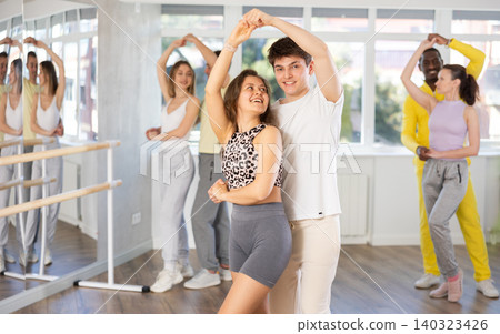 Young man and woman practicing waltz dance in pair in training hall Young man and woman practicing waltz dance in pair in training hall 140323426