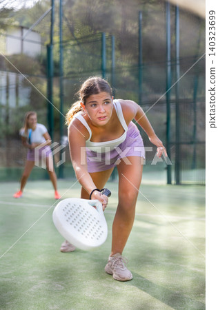 Young woman padel tennis player trains on the outdoor court Young woman padel tennis player trains on the outdoor court 140323699