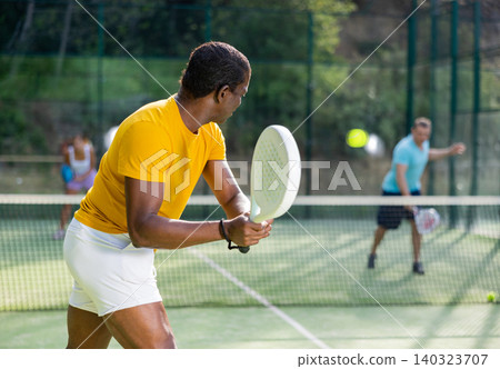 African american man padel tennis player trains on the court African american man padel tennis player trains on the court 140323707