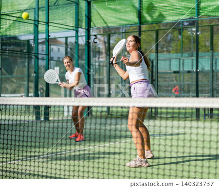 Girl playing padel tennis match during training on court 140323737
