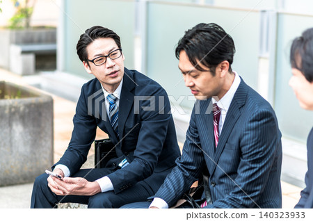 三位身著西裝的日本商人正在戶外聊天。 三位身著西裝的日本商人正在戶外聊天。 140323933
