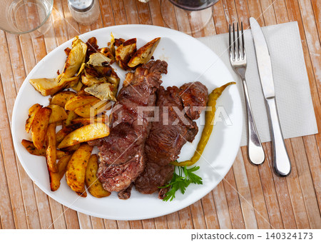 Veal steak with grilled potato and artichokes Veal steak with grilled potato and artichokes 140324173