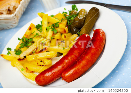Fried sausages with fries, pickles and chopped greens Fried sausages with fries, pickles and chopped greens 140324200