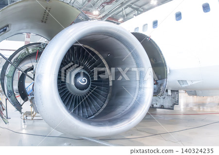Close-up of an open high bypass turbofan airplane engine of a passenger aircraft in an aviation hangar Close-up of an open high bypass turbofan airplane engine of a passenger aircraft in an aviation hangar 140324235