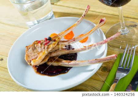 Baked lamb rack of ribs with carrots and sauce 140324256