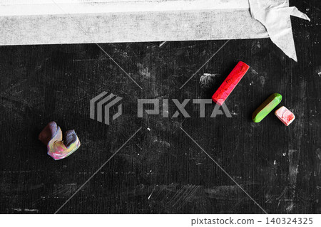 Artistic workspace with red and green pastel sticks and a kneaded eraser on a dark monochrome textured surface Artistic workspace with red and green pastel sticks and a kneaded eraser on a dark monochrome textured surface 140324325
