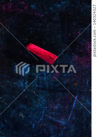 Vivid red pastel stick placed on a dark artistic background with hints of blue and magenta color smudges, Vivid red pastel stick placed on a dark artistic background with hints of blue and magenta color smudges, 140324327