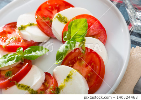 Salad caprese with tomatoes, mozzarella cheese and herbs Salad caprese with tomatoes, mozzarella cheese and herbs 140324468