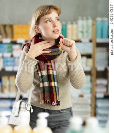 Young woman having sore throat in drugstore Young woman having sore throat in drugstore 140324537