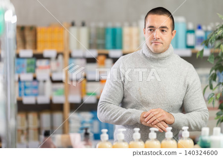 Portrait of man in winter clothes shopper choosing some products in supermarket Portrait of man in winter clothes shopper choosing some products in supermarket 140324600