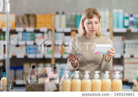 Woman scans barcode of package with pills Woman scans barcode of package with pills 140324601