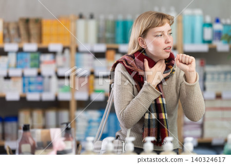 Young woman having sore throat in drugstore Young woman having sore throat in drugstore 140324617