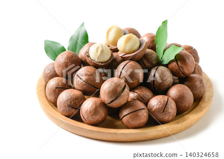 Macadamia Nuts with Kernels on Wooden Plate Isolated on White Background Macadamia Nuts with Kernels on Wooden Plate Isolated on White Background 140324658