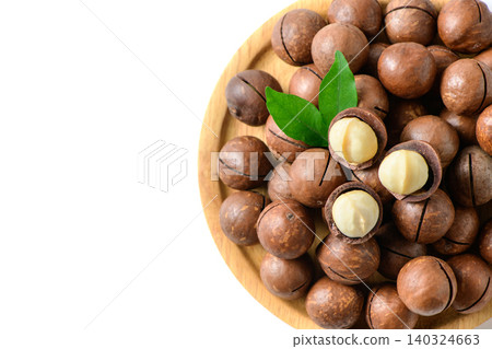 Macadamia Nuts with Kernels on Wooden Plate Isolated on White Background Macadamia Nuts with Kernels on Wooden Plate Isolated on White Background 140324663