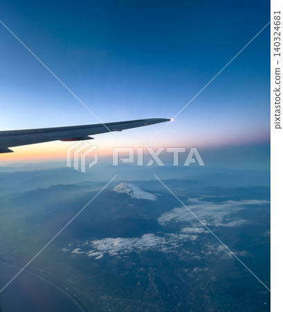 Mount Fuji and the sky at sunset, as seen from the window of an airplane. Mount Fuji and the sky at sunset, as seen from the window of an airplane. 140324681